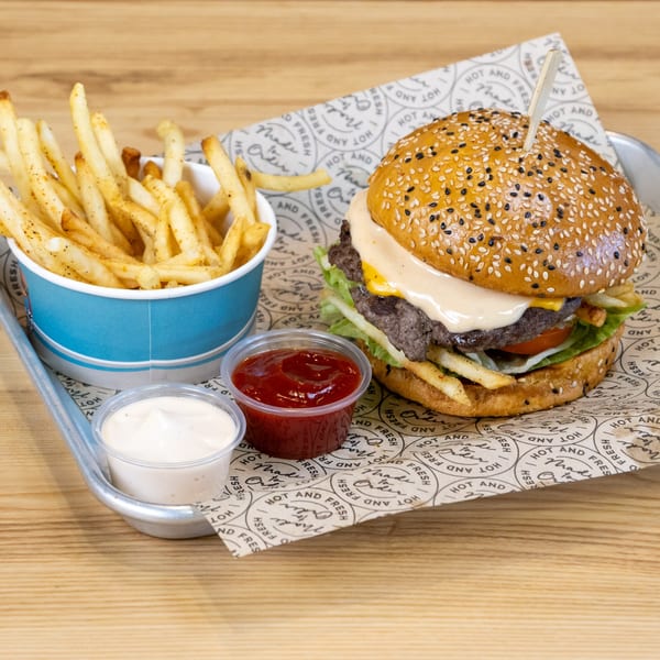 Sindbad Burger with fries, ketchup, and mayonnaise on a branded paper-lined tray.
